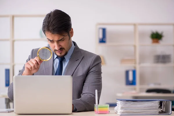 Jovem funcionário auditor segurando lupa — Fotografia de Stock