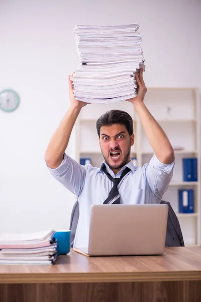 Empleado joven empresario descontento con el trabajo excesivo en la oficina — Foto de Stock