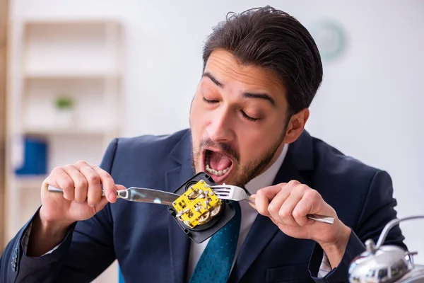 Jovem empresário empregado comer despertador-relógio — Fotografia de Stock