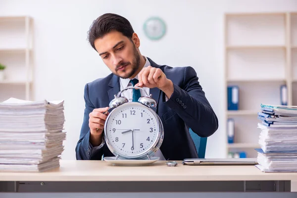 Joven empleado de negocios comiendo despertador-reloj —  Fotos de Stock