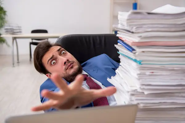 Giovane dipendente maschio e troppo lavoro in ufficio — Foto Stock