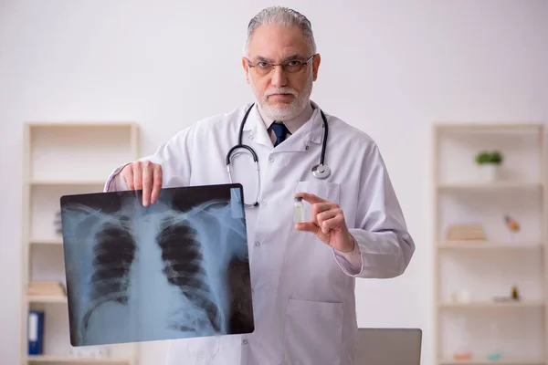 Gammal manlig röntgenläkare som arbetar på kliniken — Stockfoto