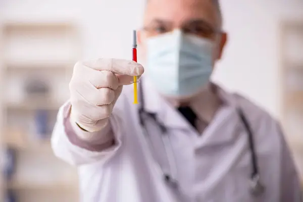 Gammal manlig läkare i vaccinationskonceptet — Stockfoto