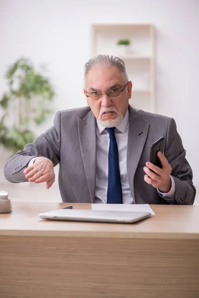 Gammal manlig anställd missnöjd med överdrivet arbete på kontoret — Stockfoto