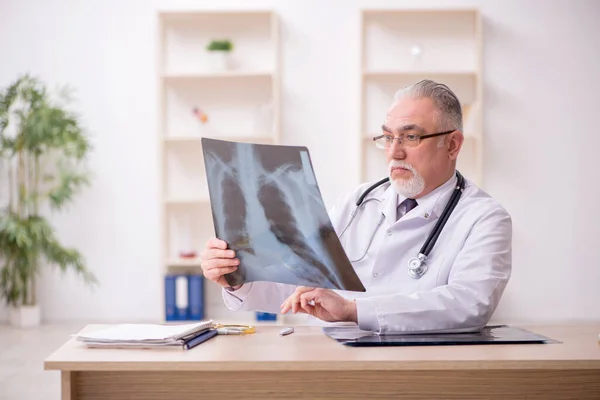 Oude mannelijke arts radioloog werkzaam in de kliniek tijdens pandemie — Stockfoto