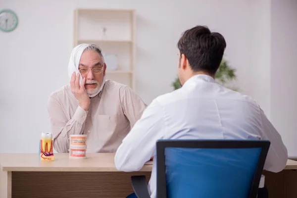 Old male patient visiting young male doctor dentist — Stock Photo, Image