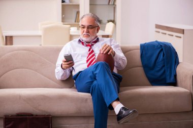 Evde televizyon izleyen yaşlı bir patron.