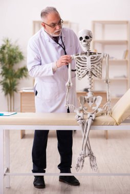 Ölü hasta yaşlı erkek doktoru ziyaret ediyor.