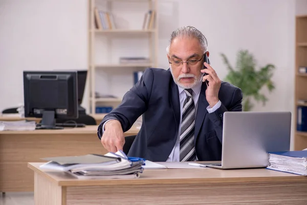 Betagter Geschäftsmann sitzt im Büro — Stockfoto