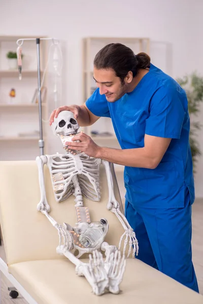 Giovane medico maschile suggerendo pillole per il paziente scheletro — Foto Stock