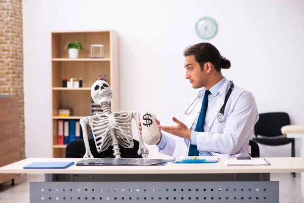 Jeune homme médecin et patient squelette en médecine coûteuse con — Photo