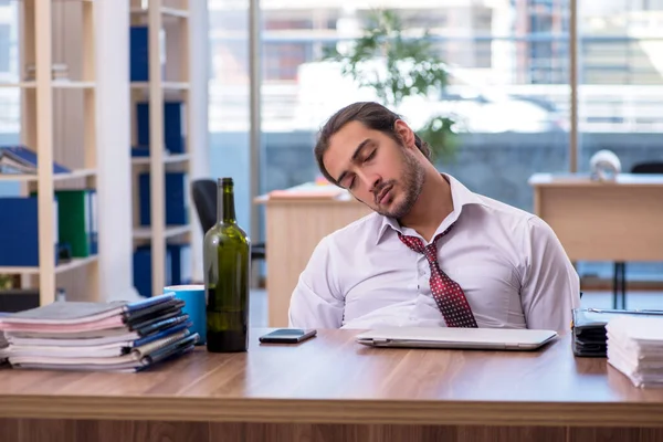 Jovem viciado em álcool masculino empregado que trabalha no escritório — Fotografia de Stock