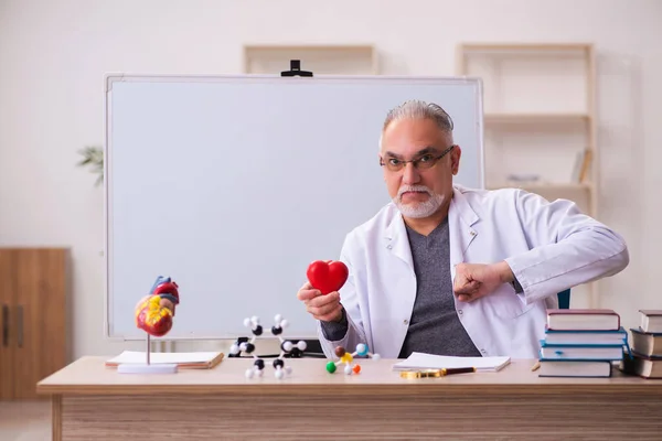 Oude mannelijke arts cardioloog zit in de klas — Stockfoto