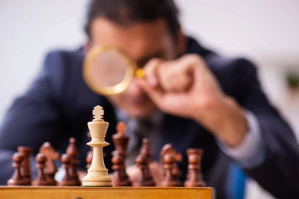 Молодий працівник чоловічої статі грає в шахи на робочому місці — стокове фото