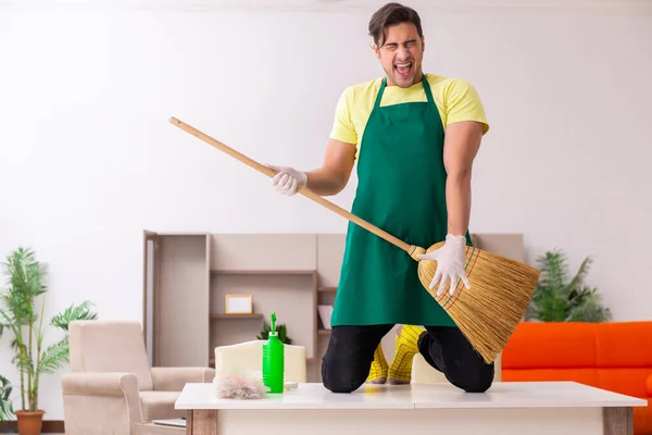 Joven contratista masculino limpiando la casa en interiores — Foto de Stock