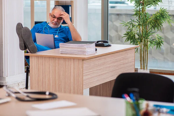 Starý lékař pracující na klinice — Stock fotografie