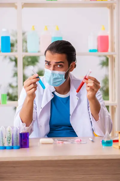 Jovem químico masculino testando sabão no laboratório — Fotografia de Stock