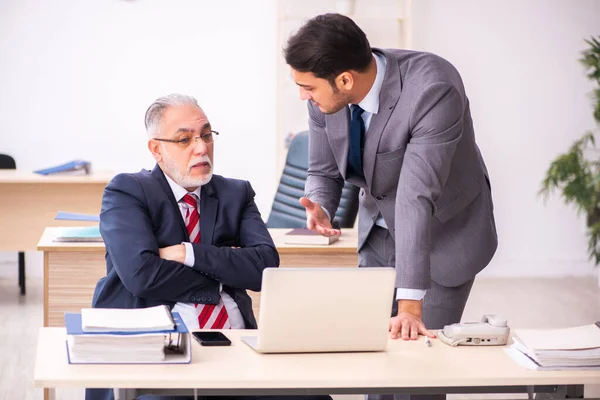 Ancien patron et jeune employé masculin travaillant dans le bureau — Photo