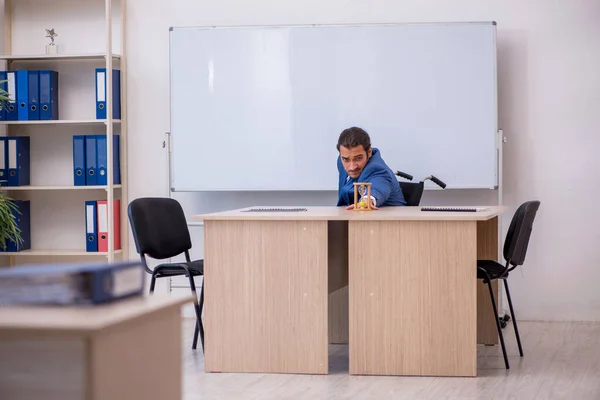 Młody pracownik na wózku inwalidzkim pracujący w biurze — Zdjęcie stockowe