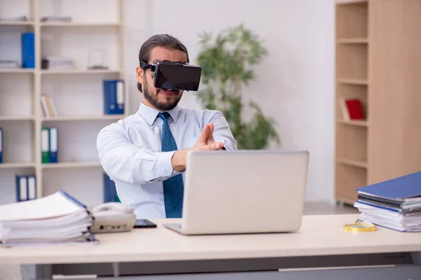Jovem funcionário masculino vestindo óculos virtuais no local de trabalho — Fotografia de Stock