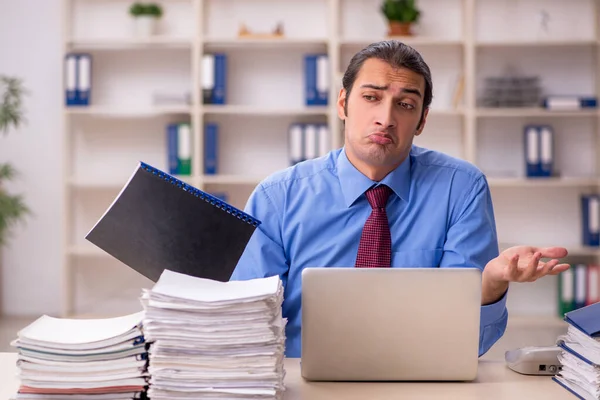 Giovane dipendente maschio infelice con il lavoro eccessivo — Foto Stock