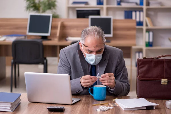 Coronavirus smittade gamla affärsman anställd sitter i off — Stockfoto