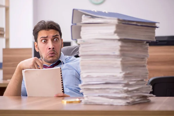 Jonge mannelijke werknemer ongelukkig met overmatig werk in het kantoor — Stockfoto