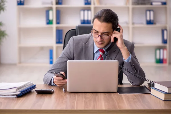 Jeune employé masculin assis sur le lieu de travail — Photo