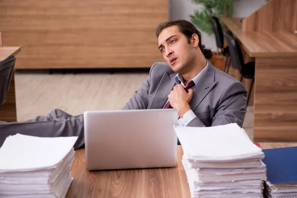 Joven empleado masculino descontento con el trabajo excesivo en la oficina — Foto de Stock