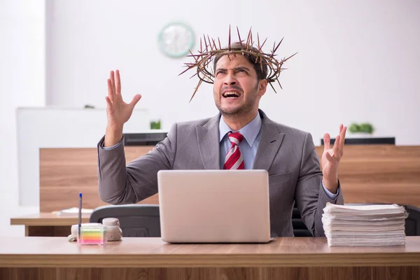 Junge männliche Angestellte trägt stacheligen Kranz auf dem Kopf — Stockfoto