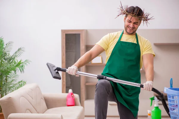 Jonge mannelijke aannemer draagt stekelige krans op het hoofd schoonmaken th — Stockfoto