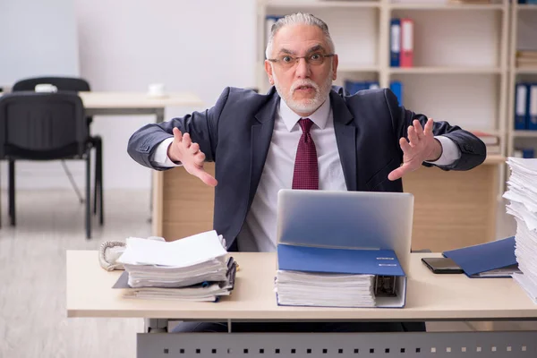 Dipendente di sesso maschile anziano e troppo lavoro sul posto di lavoro — Foto Stock