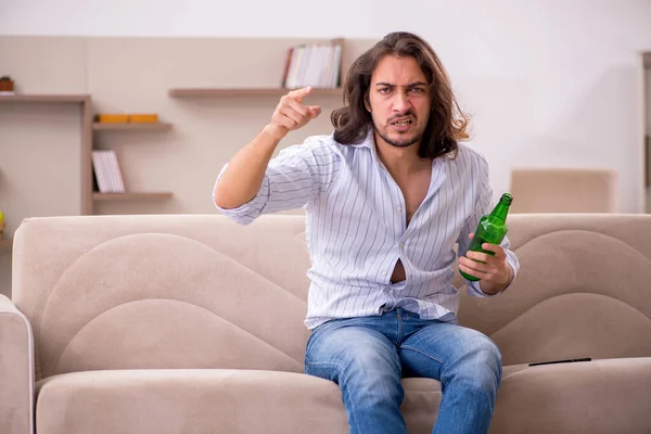 Jeune homme buvant de l'alcool à la maison — Photo