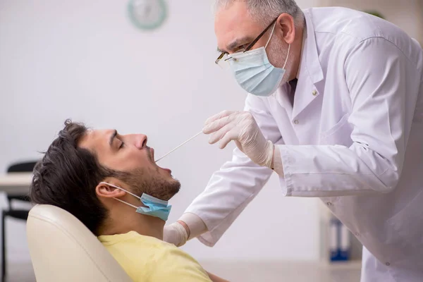 Junge männliche Patienten besuchen alte männliche Arzt HNO-Arzt — Stockfoto