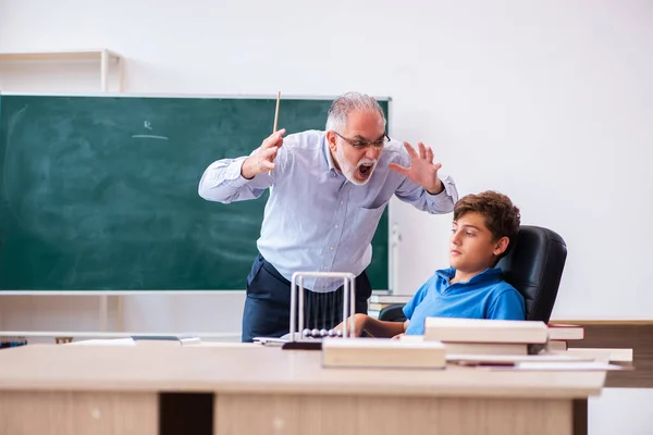 Viejo maestro y colegial en el aula — Foto de Stock