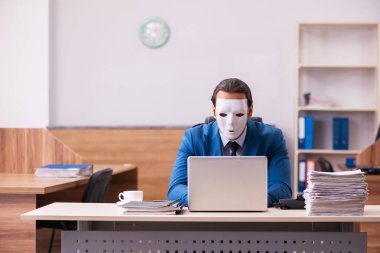 Ofiste maske takan genç bir erkek.