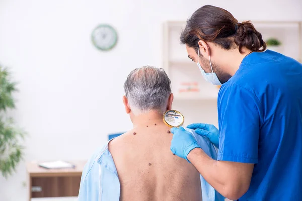 Starý muž návštěva mladý lékař dermatolog — Stock fotografie