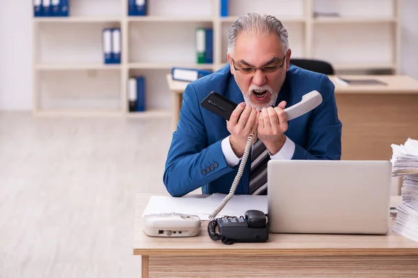 Velho empregado masculino e muito trabalho no escritório — Fotografia de Stock