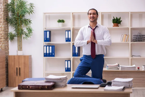 Young male employee doing yoga exercises during break — Stock Photo, Image