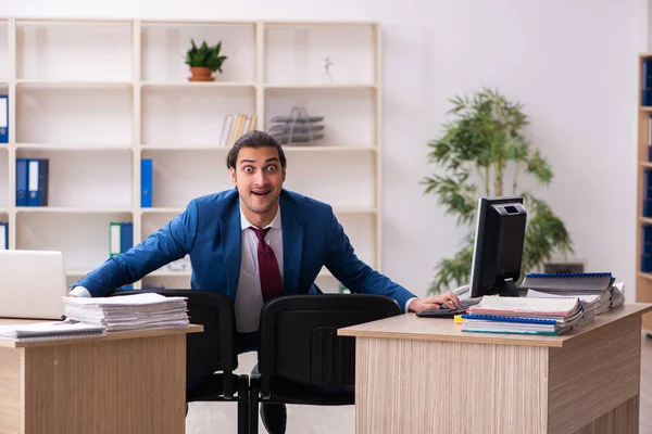 Mladý muž zaměstnanec v konceptu multitasking — Stock fotografie