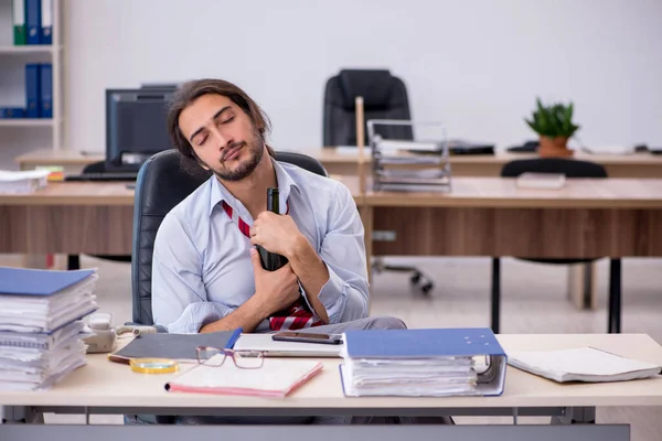 Junge männliche Angestellte trinkt Alkohol im Büro — Stockfoto