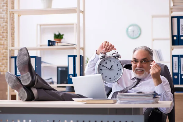 Old male employee in time management concept — Stock Photo, Image