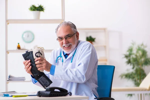 Vieux médecin homme tenant sac d'argent à l'hôpital — Photo