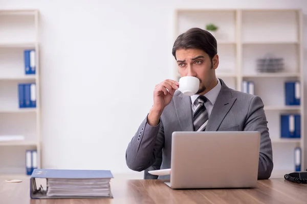 Ung manlig anställd dricker kaffe under rasten — Stockfoto