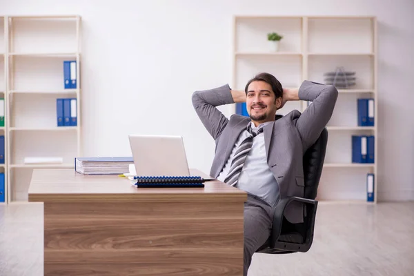 Junge attraktive männliche Mitarbeiter sitzen am Arbeitsplatz — Stockfoto