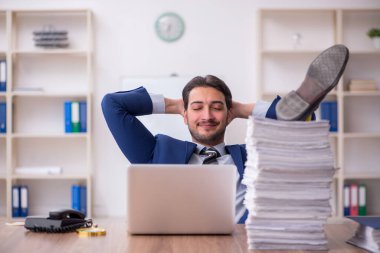 Ofisteki aşırı işten memnun olmayan genç bir erkek işçi.