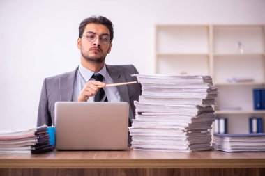 Komik genç erkek çalışan sihirbaz ve ofiste çok fazla iş var.