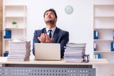 Genç işadamı ve ofiste çok fazla iş var.