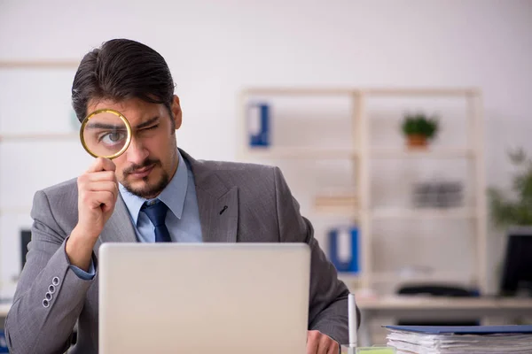 Jonge mannelijke werknemer auditor houden vergrootglas — Stockfoto