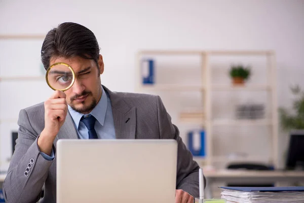 Joven empleado auditor sosteniendo lupa — Foto de Stock